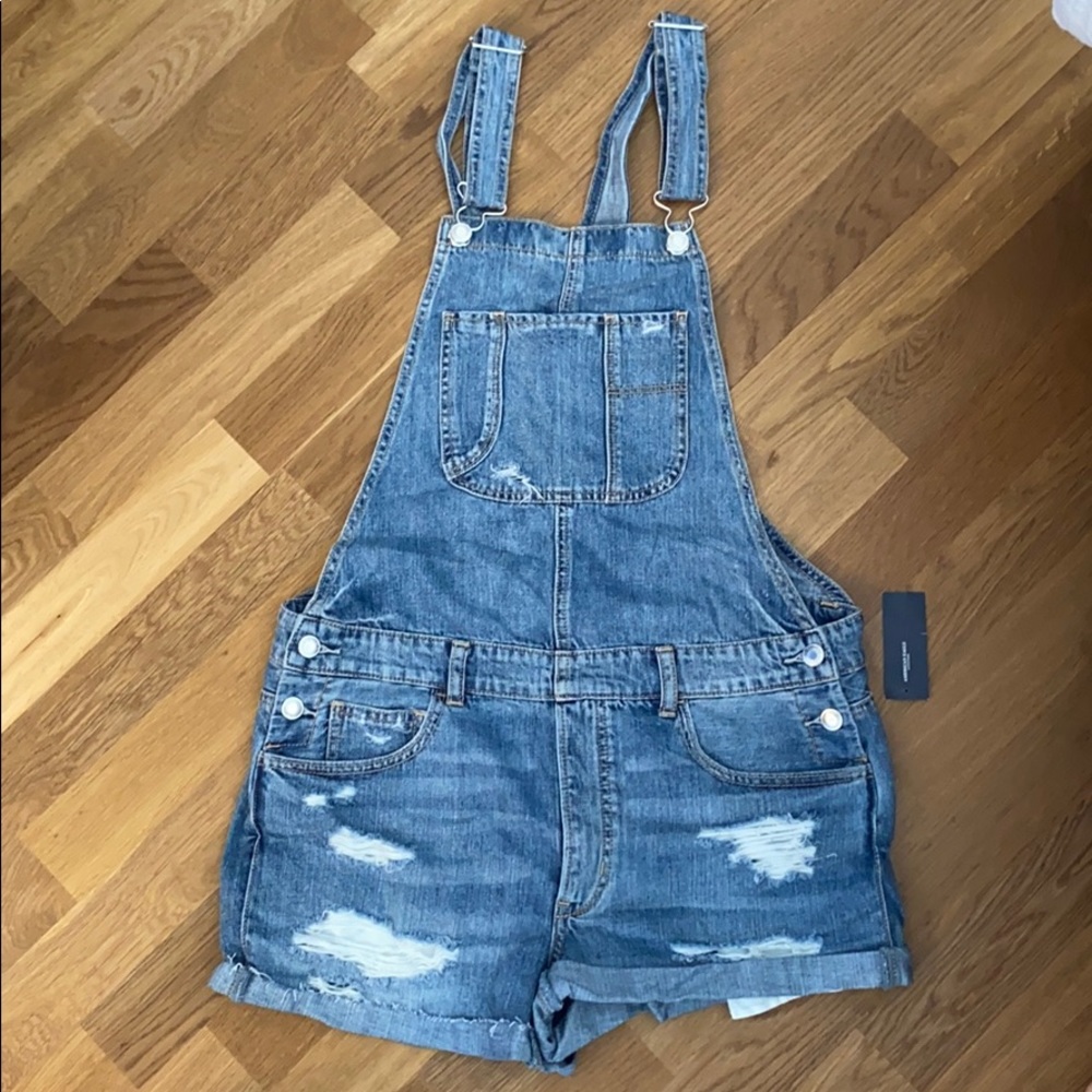 Distressed denim overalls